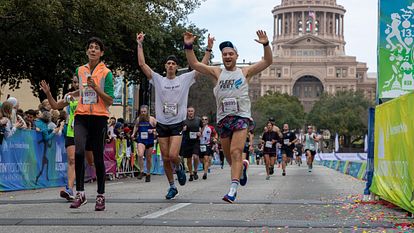 Runners celebrate while crossing the finish line of the 2022 Austin Marathon. 